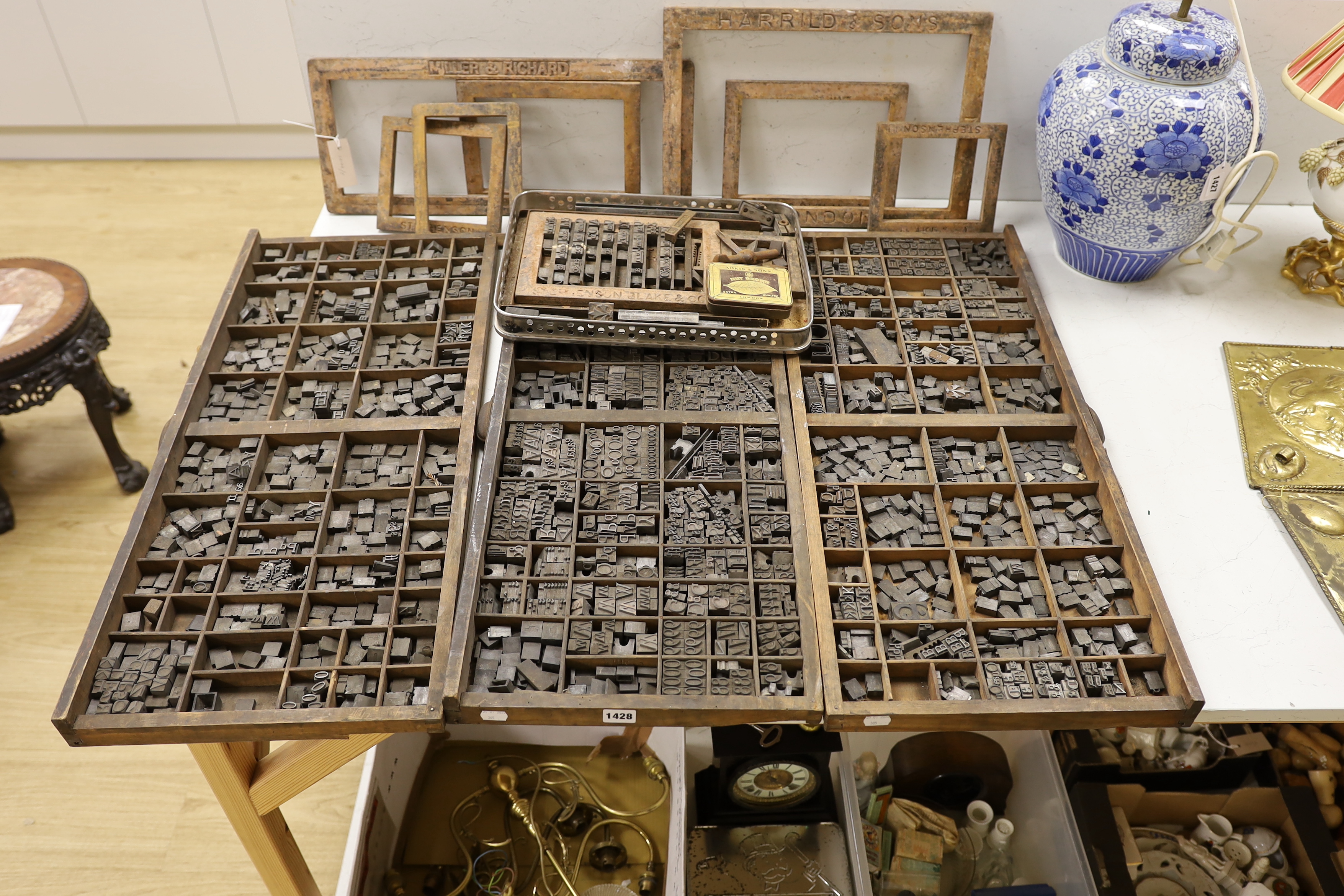 Three trays of metal printing type: chases, quoins and spacing bars